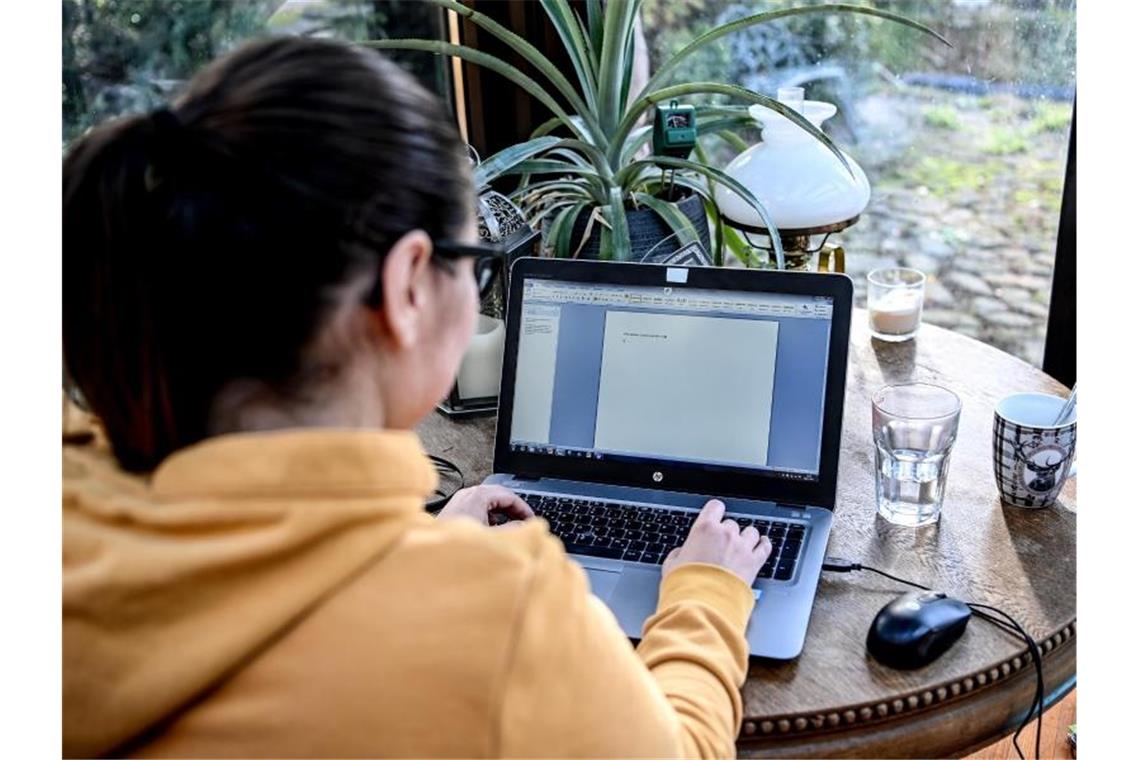 Eine junge Frau arbeitet im Homeoffice in einem Wintergarten. Der von der Corona-Krise ausgelöste Trend zum Homeoffice wird die Wirtschaft in Deutschland langfristig verändern. Foto: Britta Pedersen/dpa-Zentralbild/dpa