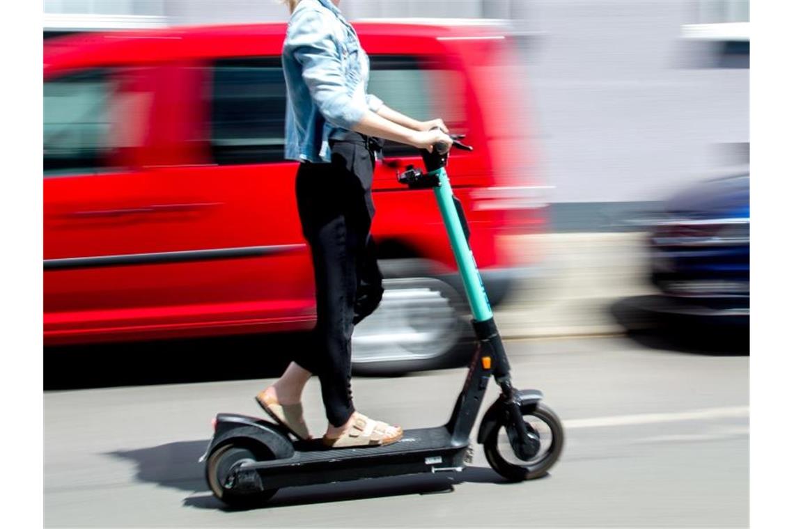 Eine junge Frau unterwegs mit einem E-Scooter in Hannover. Foto: Hauke-Christian Dittrich/dpa