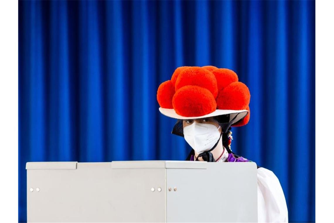 Eine junge Frauen in traditioneller Schwarzwälder Tracht gibt in der Festhalle in Gutach in Baden-Württemberg ihre Stimme ab. Foto: Philipp von Ditfurth/dpa
