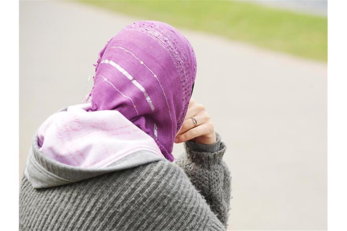 Eine junge Muslimin trägt ein Kopftuch zu einem modernen, westlichen Kapuzenpullover. Foto: Wolfram Steinberg/Illustration