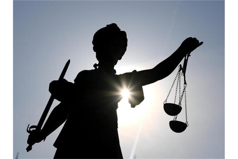 Eine Justitia-Statue ist im Gegenlicht zu sehen. Foto: Arne Dedert/dpa/Archivbild