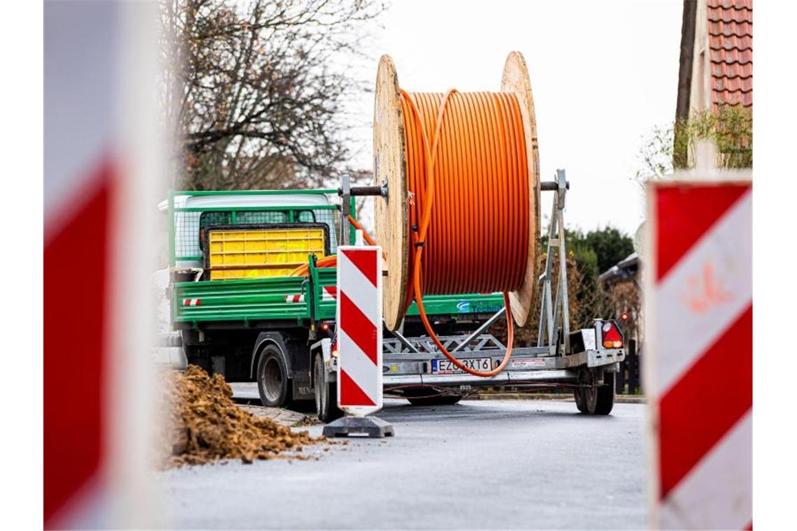 Eine Kabeltrommel mit Glasfaserkabel steht auf einer Baustelle auf dem Anhänger eines Lastwagens. Foto: Moritz Frankenberg/dpa/Symbolbild
