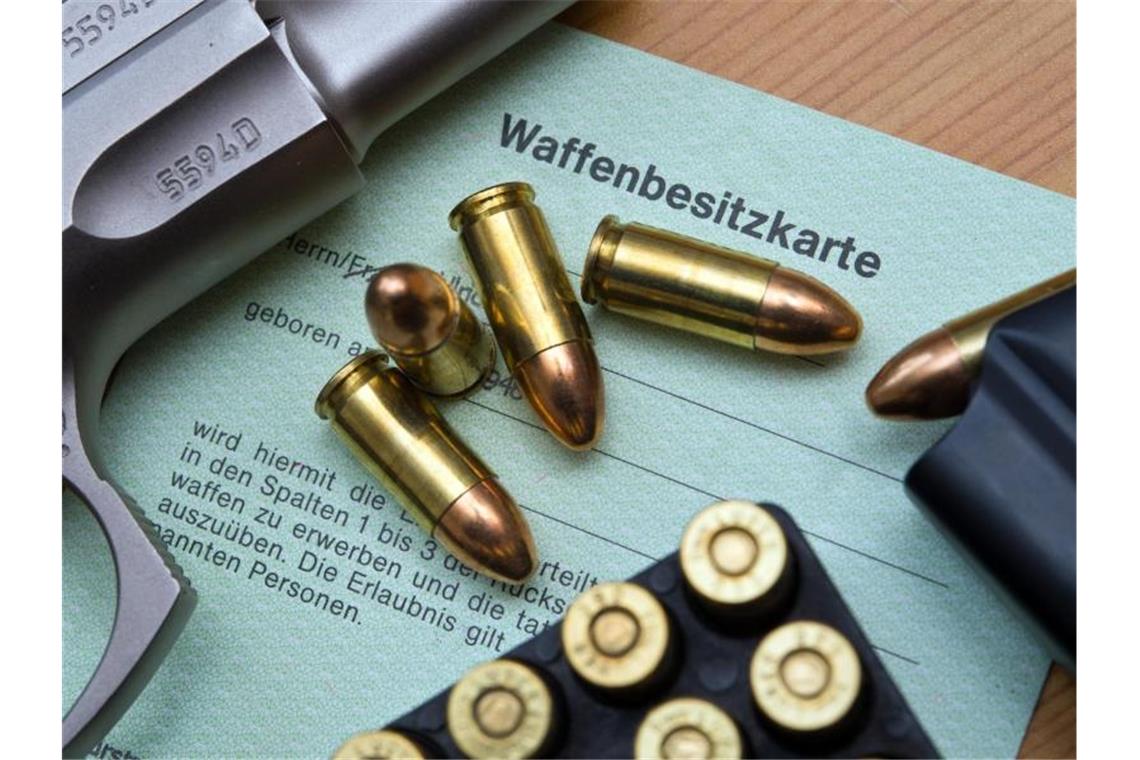 Eine Kaliber 9 mm Pistole, Patronen und ein Magazin liegen auf einer Waffenbesitzkarte. Foto: Patrick Pleul/dpa-Zentralbild/dpa