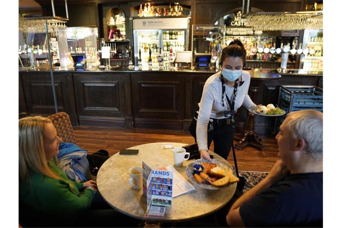 Eine Kellnerin bringt zwei Gästen in einem Pub in Newcastle eine Mahlzeit an den Tisch. Foto: Owen Humphreys/PA Wire/dpa