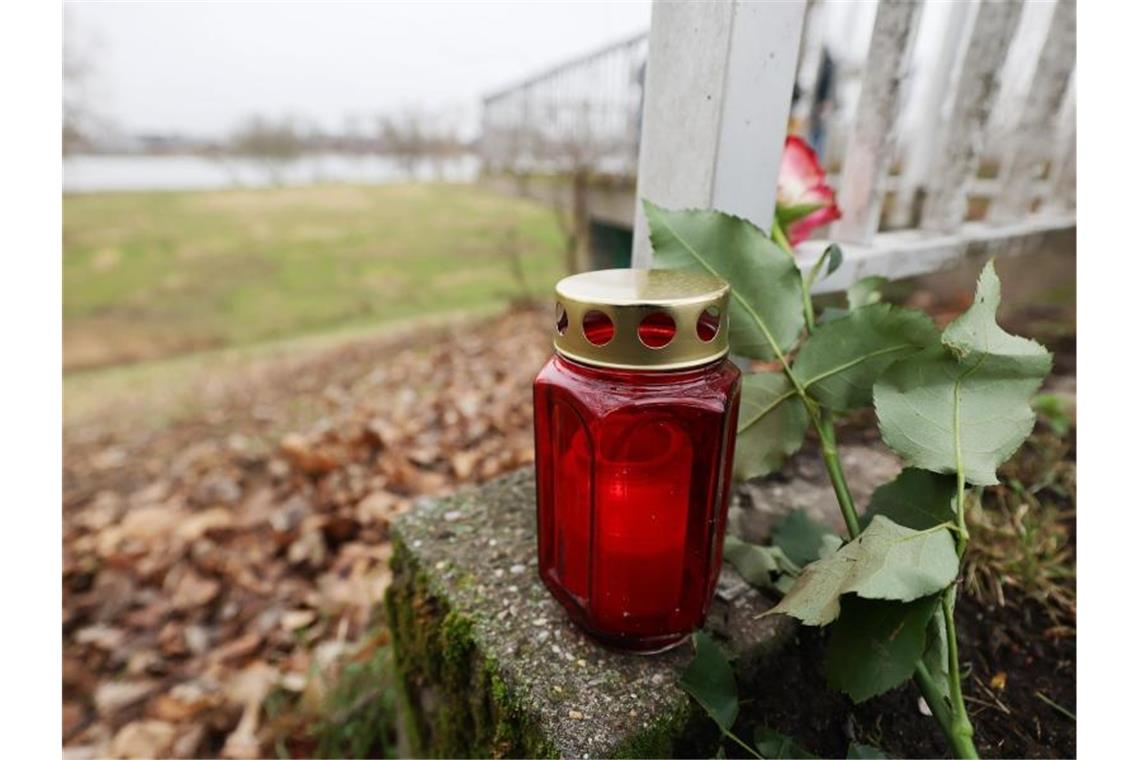 Toter Säugling am Rhein - Festgenommene ist leibliche Mutter Eine Kerze und eine Rose liegen in der Nähe des Fundortes des toten Babys. Foto: Oliver Berg/dpa