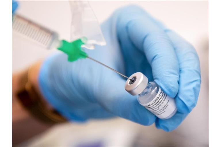Eine Klinik-Mitarbeiterin zieht den Covid-19 Impfstoff von Biontech/Pfizer für eine Impfung auf eine Spritze. Foto: Sven Hoppe/dpa/Symbolbild