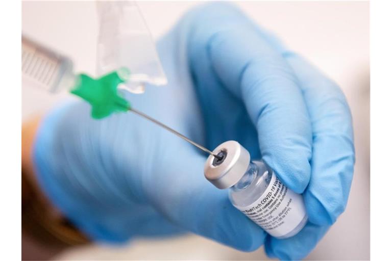 Eine Klinik-Mitarbeiterin zieht den Covid-19 Impfstoff von Biontech/Pfizer auf eine Spritze. Foto: Sven Hoppe/dpa