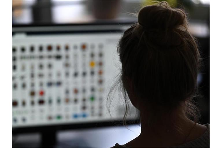 Eine Kommissarin sitzt vor einem Auswertungscomputer auf der Suche nach Kinderpornografie. Foto: Arne Dedert/dpa/Illustration