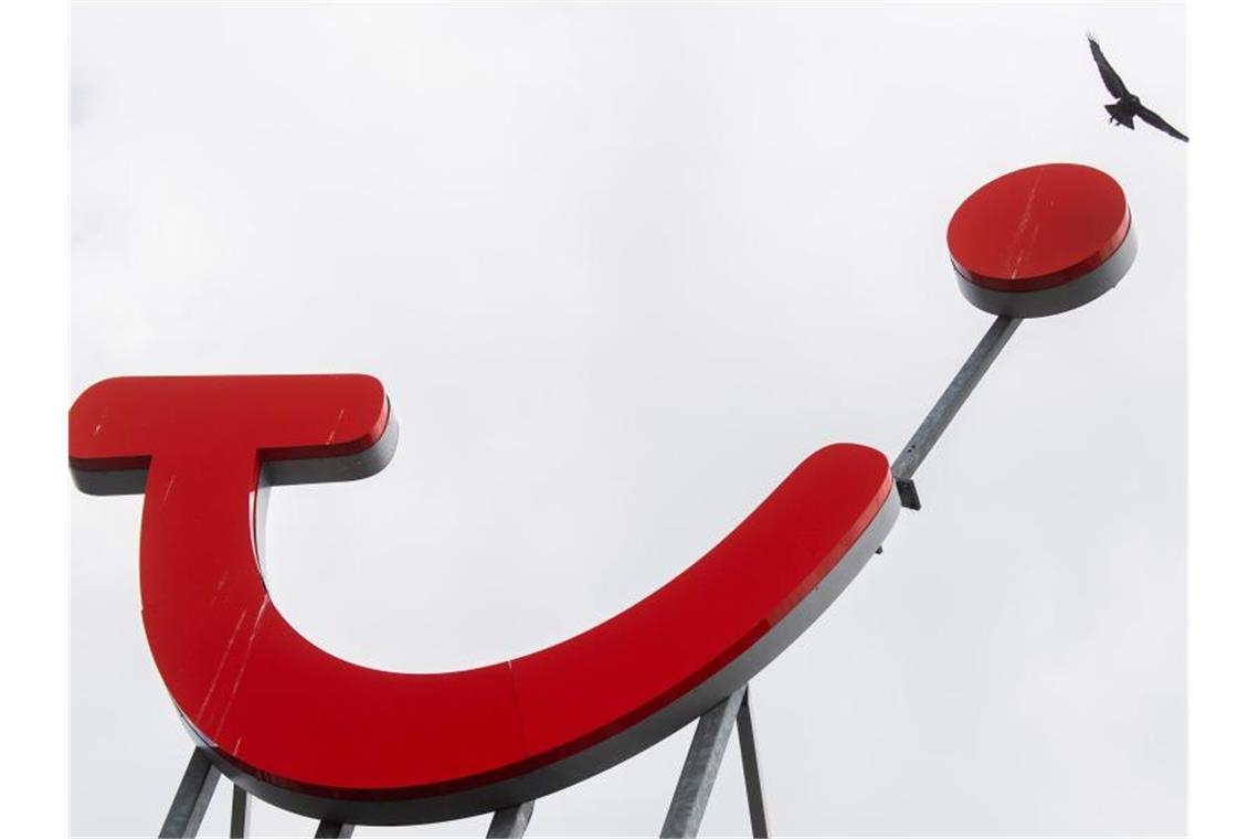 Eine Krähe fliegt über das Logo der Tui Group am Firmensitz. Foto: Julian Stratenschulte/dpa