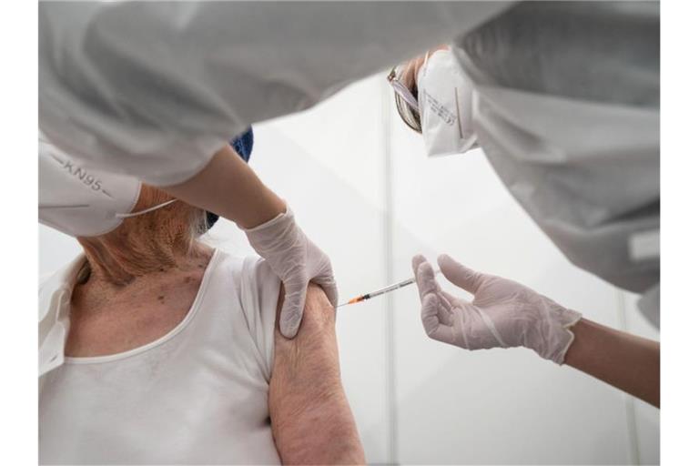 Eine Krankenpflegerin impft im Impfzentrum in der Paul-Horn-Arena in Tübingen eine Frau. Foto: Marijan Murat/dpa/Archivbild