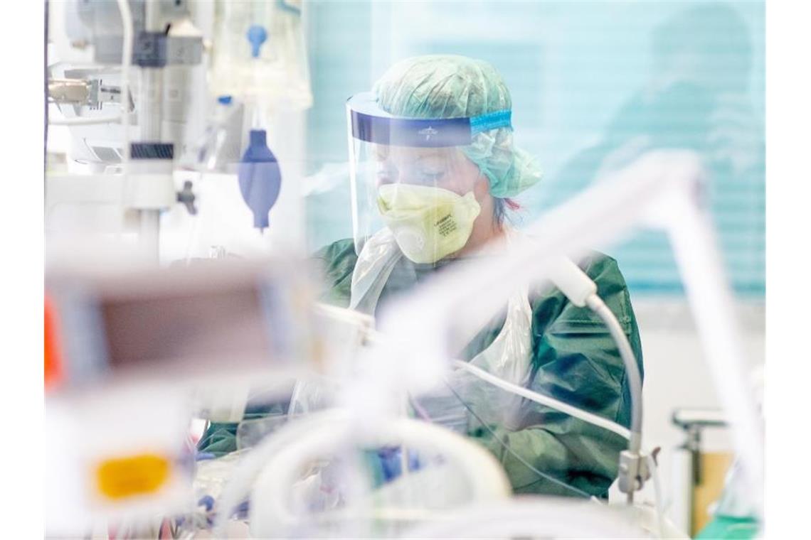 Eine Krankenpflegerin in einem Krankenzimmer auf der Intensivstation des Uniklinikums in Essen. Foto: Marcel Kusch/dpa