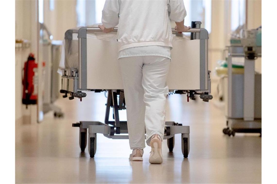 Eine Krankenpflegerin schiebt ein Krankenbett durch einen Flur. Foto: Marijan Murat/dpa/Symbolbild