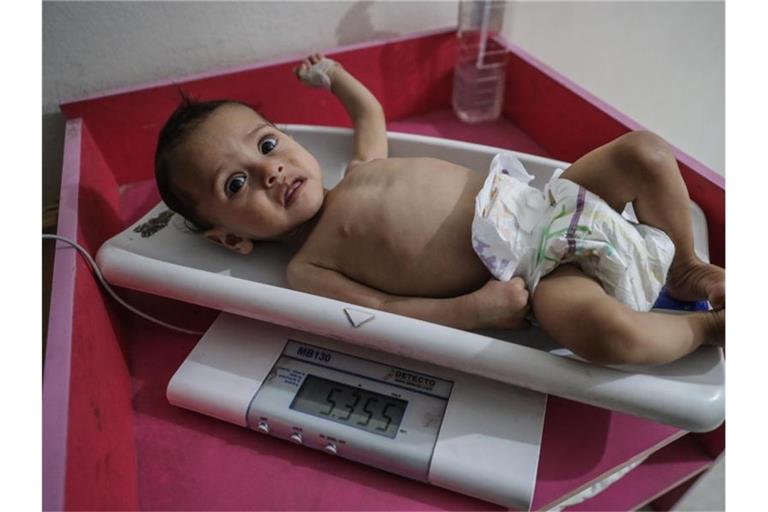 Eine Krankenschwester ermittelt das Gewicht eines unterernährten Kindes im Ibn Sina Krankenhaus in Idlib. Das Welternährungsprogramm (WFP) geht von 270 Millionen Menschen aus, die in 2021 akut an Hunger leiden oder davon stark gefährdet sein werden. Foto: Anas Alkharboutli/dpa
