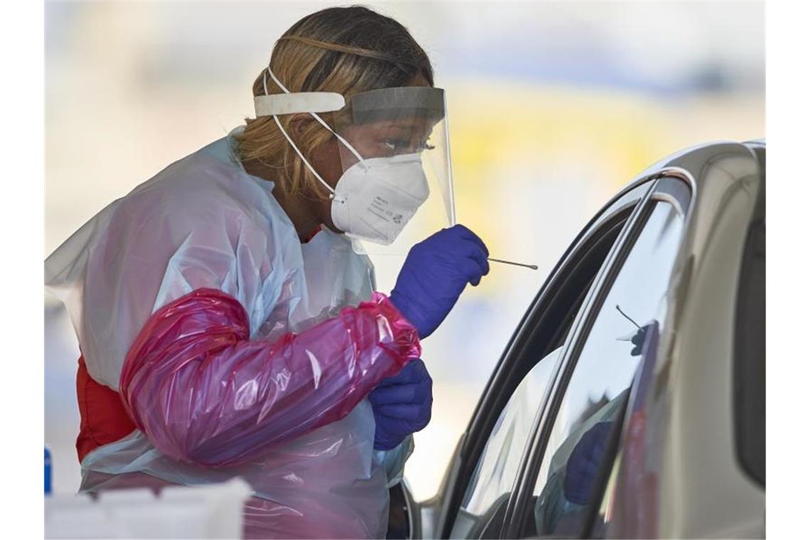 Eine Krankenschwester in Schutzanzug nimmt in Omaha einen Nasenabstrich von einem Patienten für einen Corona-Schnelltest. Foto: Nati Harnik/AP/dpa