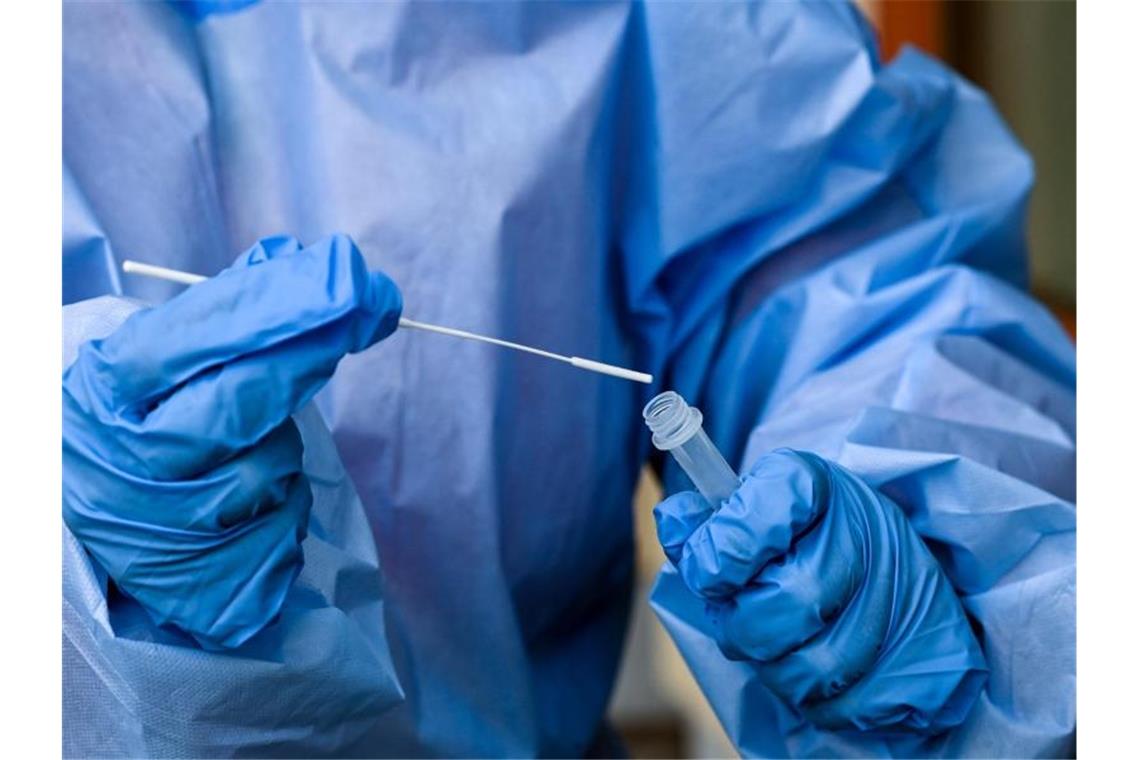 Eine Krankenschwester steckt ein Abstrichstäbchen in die Flüssigkeit eines Corona-Schnelltests. Foto: Jens Kalaene/dpa-Zentralbild/dpa/Symbolbild