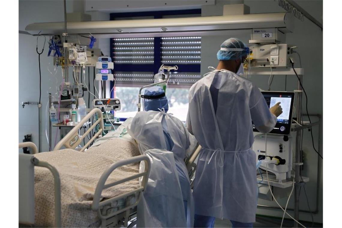 Eine Krankenschwester und ein Arzt kümmern sich um einen Patienten auf der Corona-Intensivstation in einem Lissaboner Krankenhaus. Foto: Armando Franca/AP/dpa