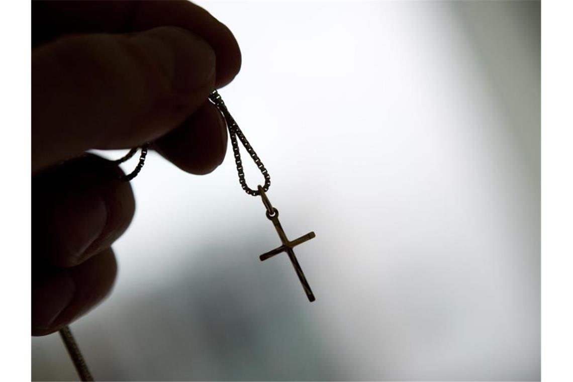 Kirche öffnet sich für digitale Begegnungen per Avatar Eine Kreuzkette wird in einer Hand gehalten. Foto: Andrea Warnecke/dpa-tmn/Symbolbild
