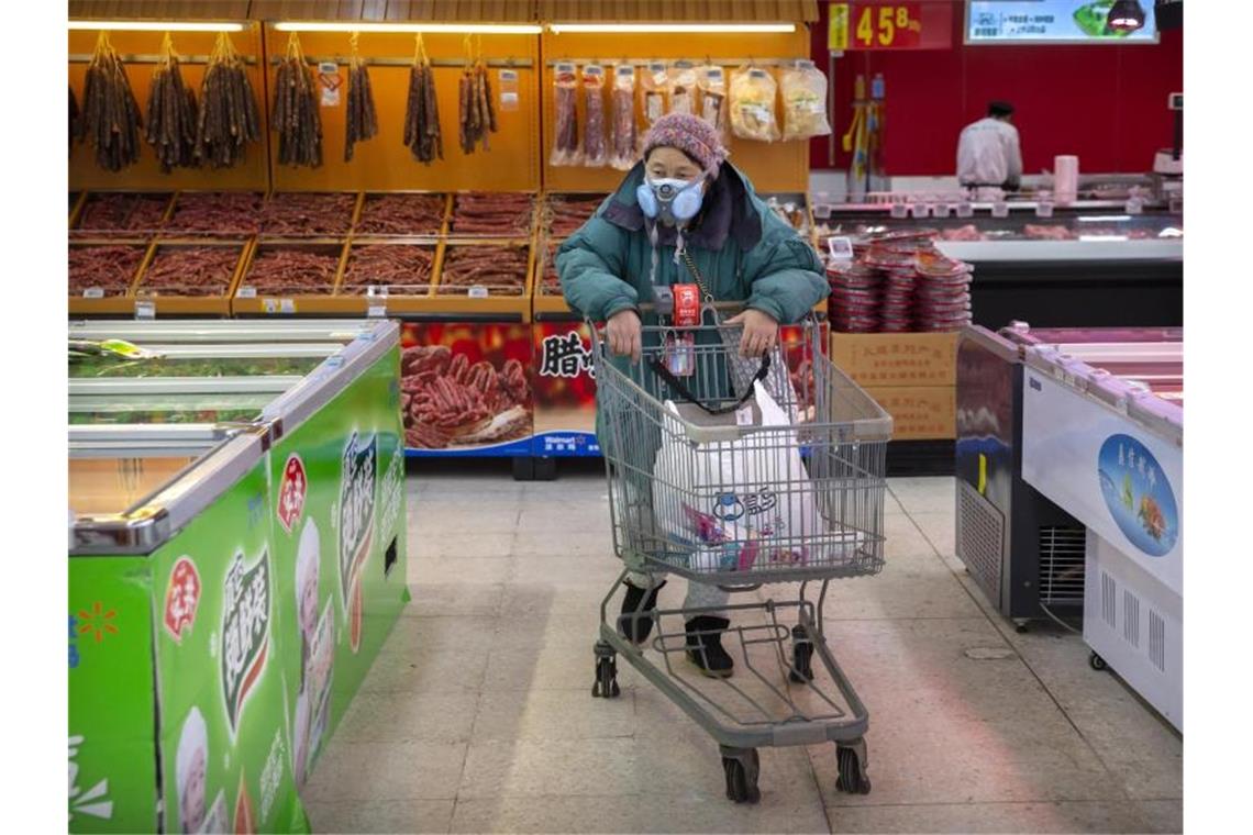 Deutsche aus Coronavirus-Gebiet in Frankfurt angekommen Eine Kundin trägt in einem Lebensmittelladen in Peking eine Atemschutzmaske. Foto: Mark Schiefelbein/AP/dpa