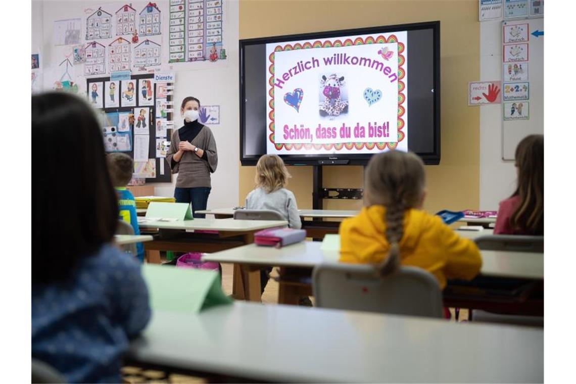 Eine Lehrerin mit FFP2-Maske unterrichtet in einer ersten Klasse. Foto: Sebastian Gollnow/dpa/Symbolbild