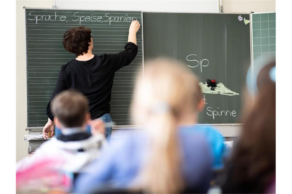 Eine Lehrerin schreibt an eine Tafel. Foto: Sebastian Gollnow/dpa/Archivbild