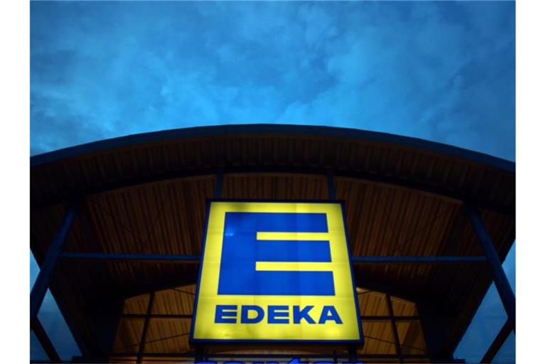 Eine Leuchtreklame weist auf einen Edeka-Markt hin. Foto: Federico Gambarini/dpa/Archivibild