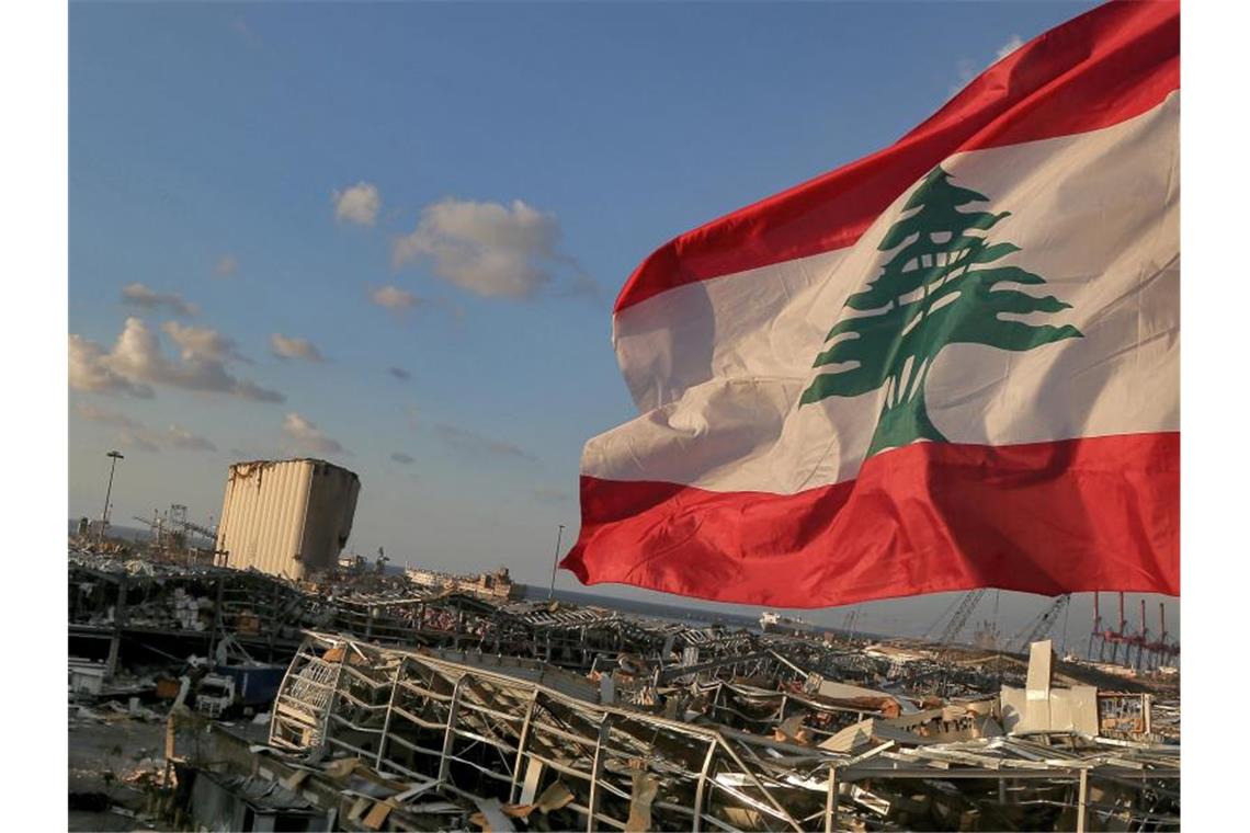 Eine libanesische Flagge weht in der Nähe der Stelle, an der eine Explosion am 4. August 2020 den Hafen von Beirut in Schutt und Asche legte. Foto: Marwan Naamani/dpa