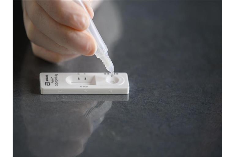 Eine Lösung wird auf eine Testkassette eines Corona-Schnelltests aufgeträufelt. Foto: Robert Michael/dpa-Zentralbild/dpa/Symbolbild