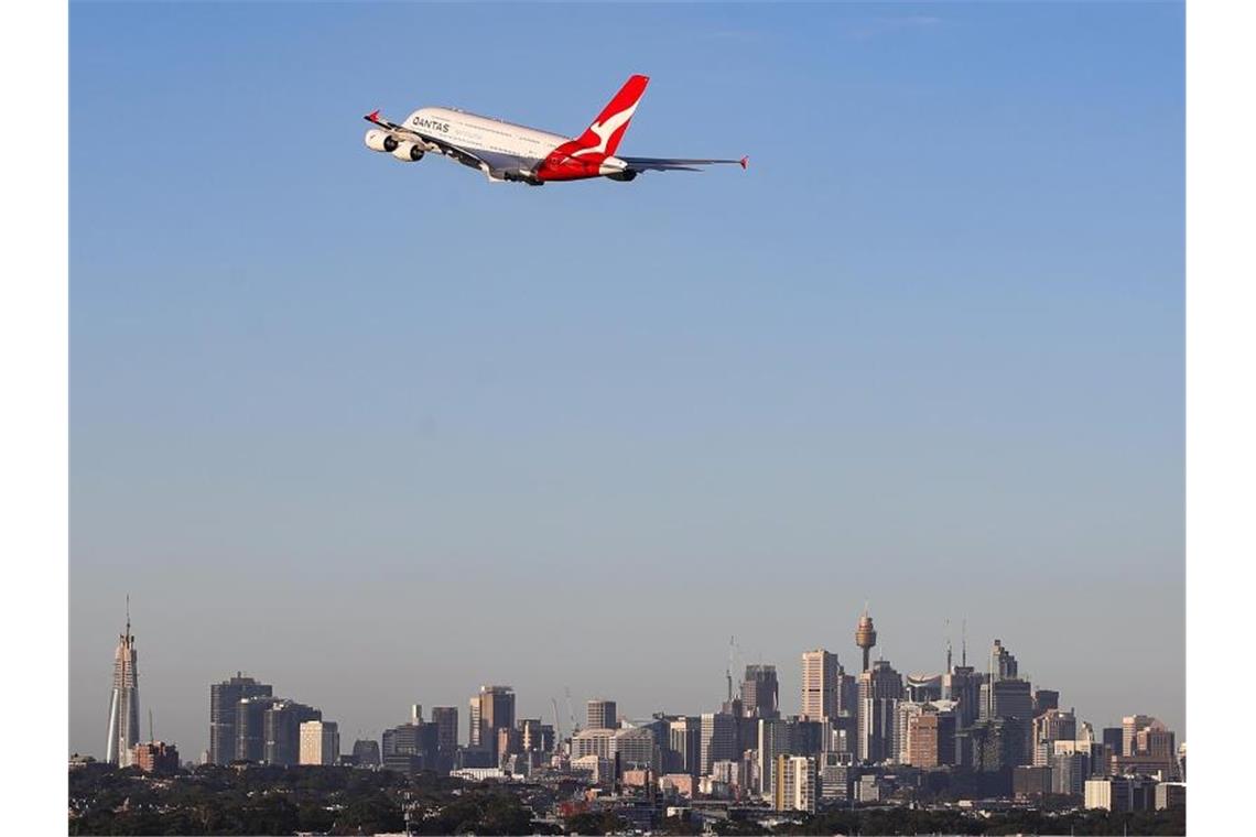 Eine Maschine der australischen Fluggesellschaft Qantas fliegt über Sydney. Foto: Bai Xuefei/Xinhua/dpa