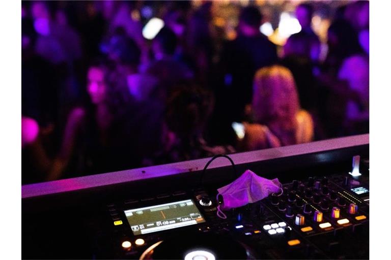 Eine Maske liegt in einem Club auf dem DJ-Pult. Foto: Philipp von Ditfurth/dpa/Symbolbild