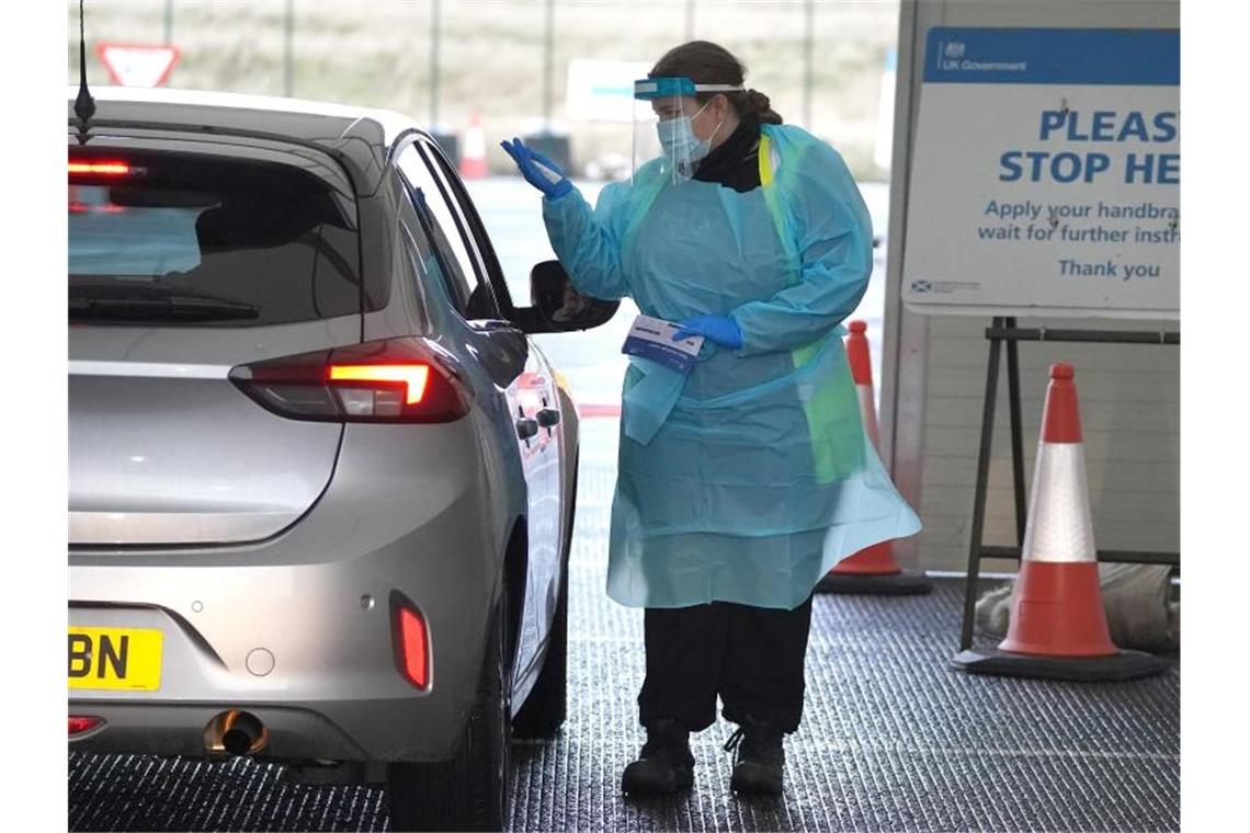 Neuer Tagesrekord an Corona-Fällen in Großbritannien Eine Medizinerin entnimmt einem Bürger eine Probe auf dem Corona-Testgelände am Flughafen Edinburgh. Foto: Andrew Milligan/PA Wire/dpa