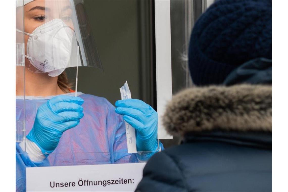 Eine medizinische Mitarbeiterin in Hannover-Laatzen testet eine Patientin auf das Corona-Virus. Corona-Daten aus mehreren Bundesländern deuten auf einen wesentlich höheren Anteil an Neuinfektionen unter Ungeimpften hin als unter Menschen mit vollständigem Impfschutz. Foto: Julian Stratenschulte/dpa