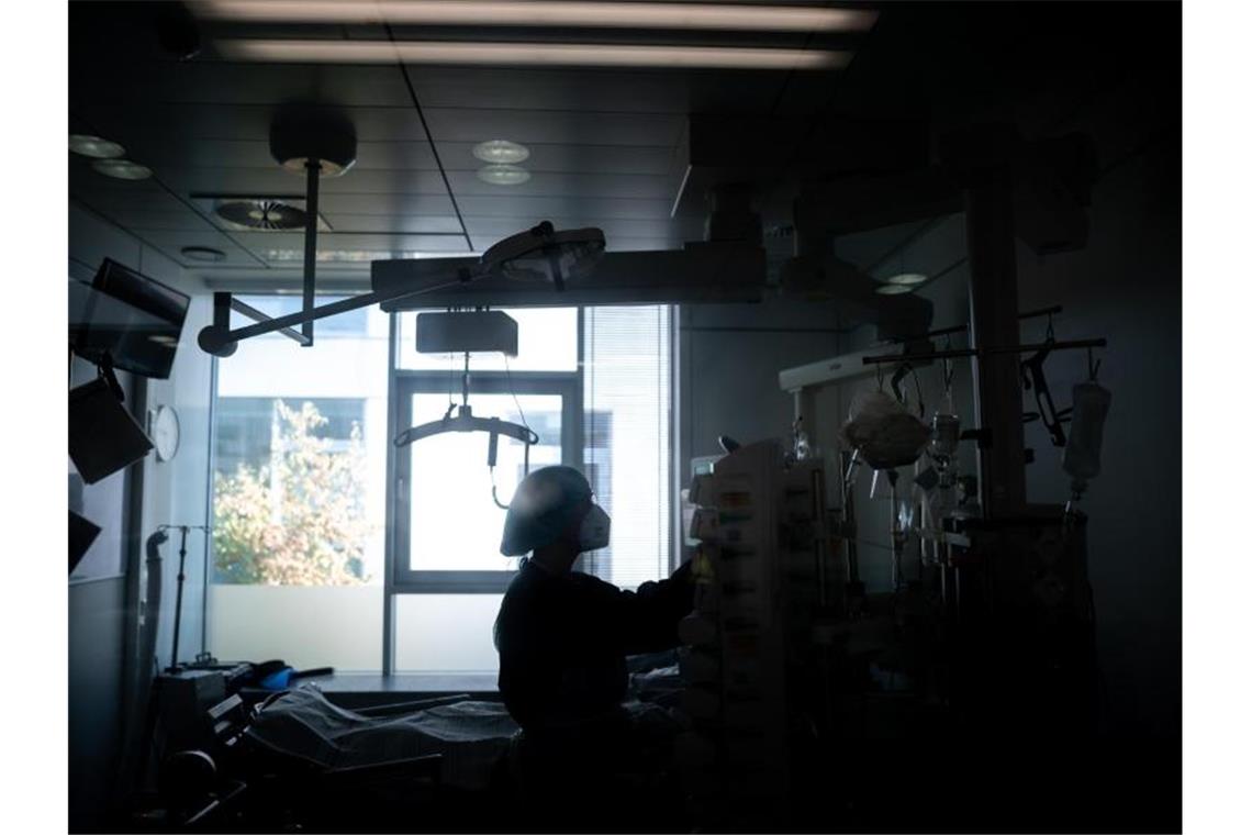 Eine Medizinische Mitarbeiterin steht in einem Zimmer einer Corona-Intensivstation. Foto: Fabian Strauch/dpa/Illustration