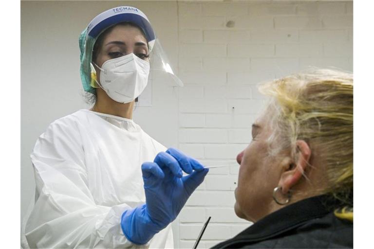 Eine medizinische Mitarbeiterin testet eine Frau auf das Coronavirus in einer Corona-Teststelle. Foto: Markku Ulander/Lehtikuva/dpa
