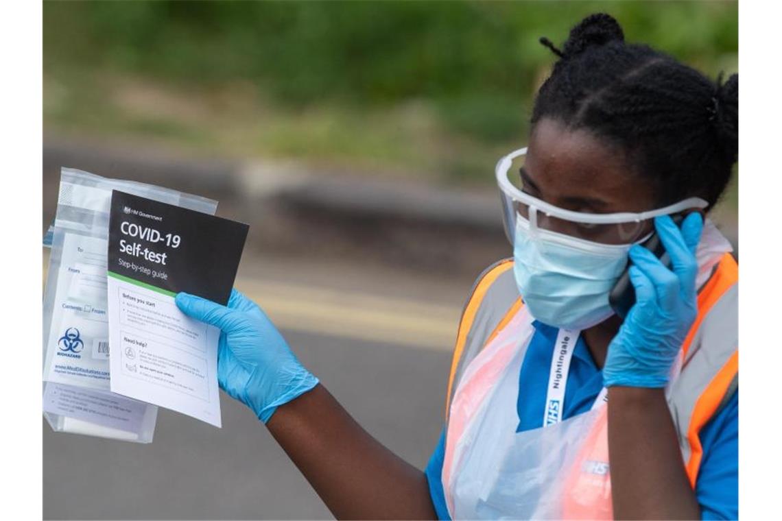 Eine medizinische Mitarbeiterin verteilt Selbsttest-Kits in einem Corona-Testzentrum im Londoner Stadtbezirk Southwark. Foto: Dominic Lipinski/PA Wire/dpa