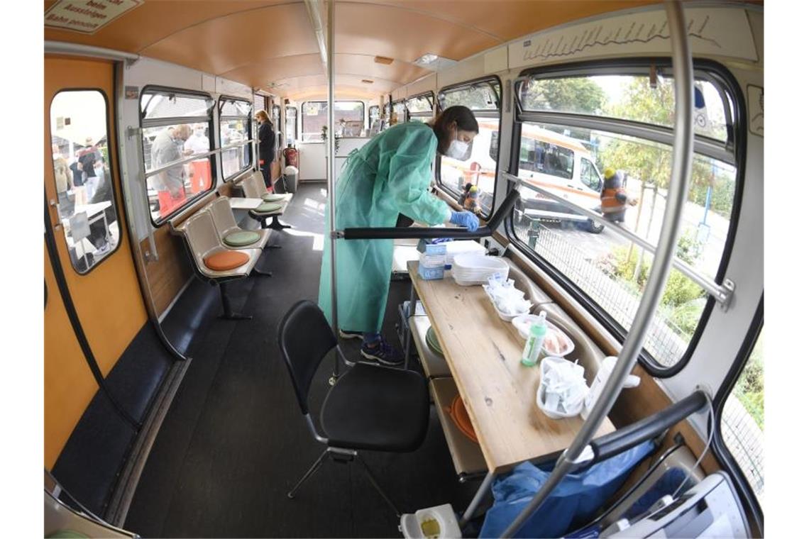 Eine medizisch-technische Assistentin bereitet in einem stillgelegten Schwebebahnwagen in Wuppertal Corona-Impfungen vor. Eine bundesweite Impfaktionswoche soll neue Fortschritte bringen. Foto: Roberto Pfeil/dpa