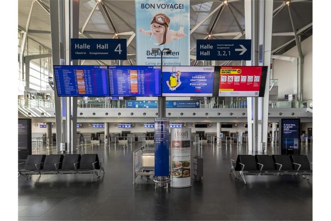 Eine menschenleere Abflughalle am Flughafen EuroAirport. Foto: Georgios Kefalas/KEYSTONE/dpa/Archivbild