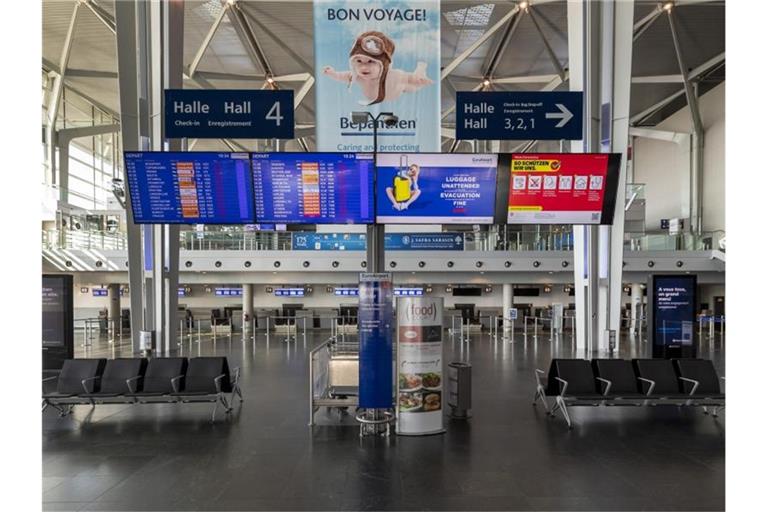 Eine menschenleere Abflughalle am Flughafen EuroAirport. Foto: Georgios Kefalas/KEYSTONE/dpa/Archivbild