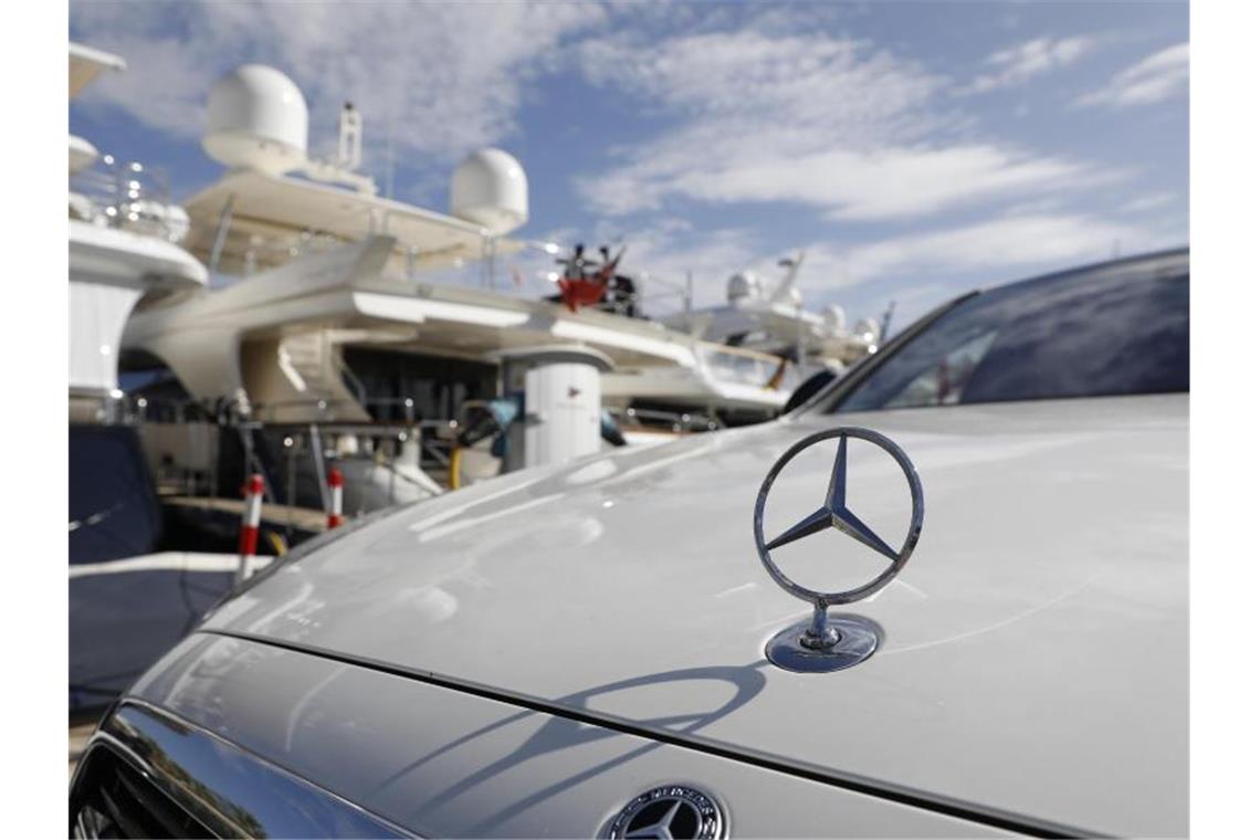 Eine Mercedes Limousine steht im Hafen von Puerto Portals vor Yachten. Lange wurde Mallorca als „Putzfrauen-Insel“ verspottet, dann wurde sie für „Sauftouristen“ geschmäht. Plötzlich erlebt die Insel einen Ansturm der Reichen. Foto: Clara Margais/dpa