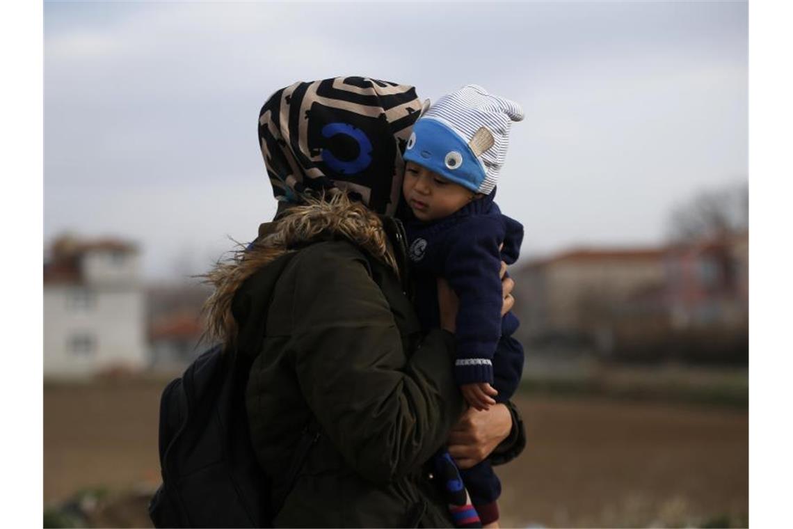 Eine Migrantin mit ihrem Kind in der Nähe der türkisch-griechischen Grenze. Foto: Emrah Gurel/AP/dpa