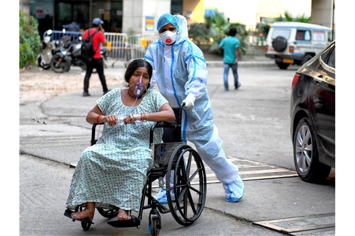Virusvariante aus Indien unter besonderer Beobachtung Eine mit dem Coronavirus infizierte Patientin sitzt im Rollstuhl und wird in das Kolkata Medical College Hospital eingeliefert. Foto: Avishek Das/SOPA Images via ZUMA Wire/dpa