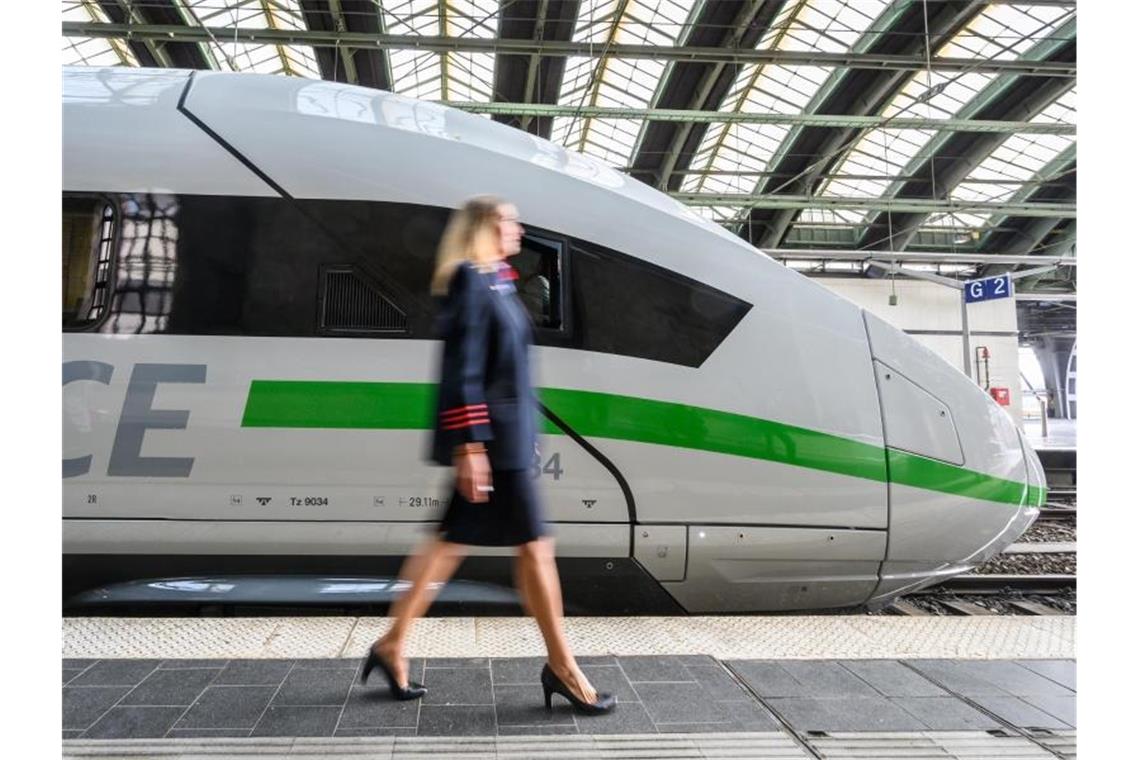 Eine Mitarbeiterin der Bahn geht an einem ICE mit dem neuen Design vorbei. Foto: Christophe Gateau