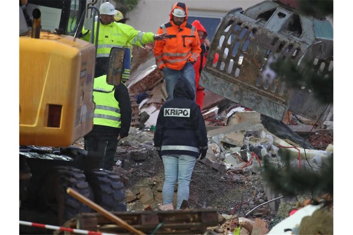 Defekte Gasleitung: Explosion tötet Vater und Tochter Eine Mitarbeiterin der Kriminalpolizei steht in den Trümmern eines zerstörten Hauses. Am Morgen wurde dort die Leiche eines Mädchens gefunden. Foto: Karl-Josef Hildenbrand