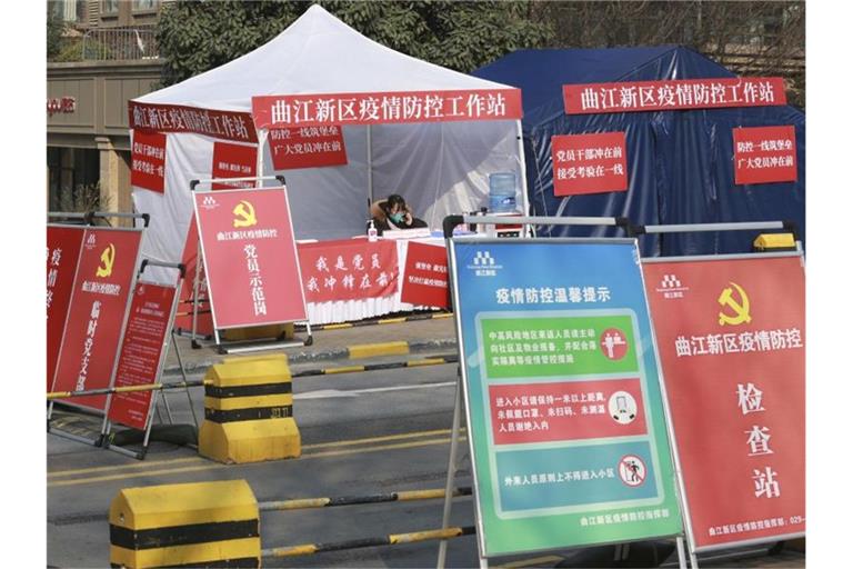 Eine Mitarbeiterin der Regierung an einem Kontrollpunkt vor einem Wohnblock in der Stadt Xi'an. Foto: Uncredited/CHINATOPIX/AP/dpa