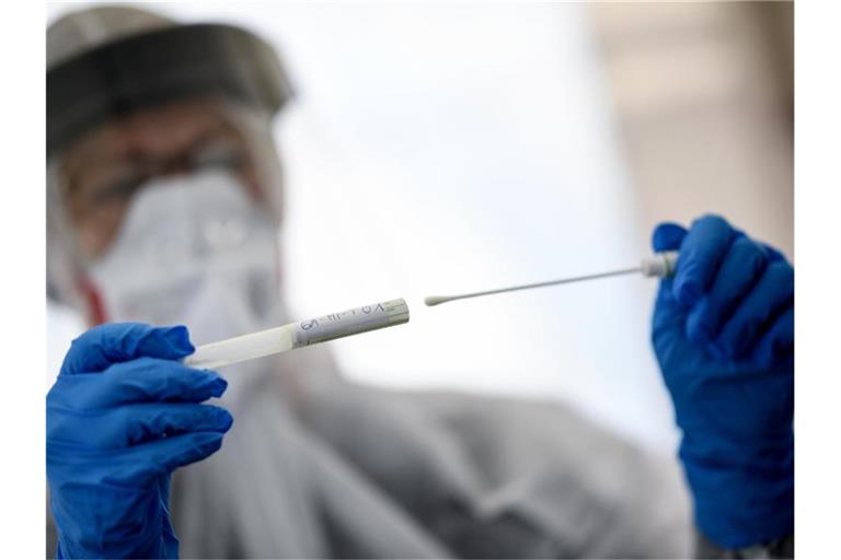 Eine Mitarbeiterin des Gesundheitsamts in Berlin-Mitte hält ein Abstrichstäbchen in einer ambulanten Test-Einrichtung in der Hand. Foto: Britta Pedersen/dpa-Zentralbild/dpa