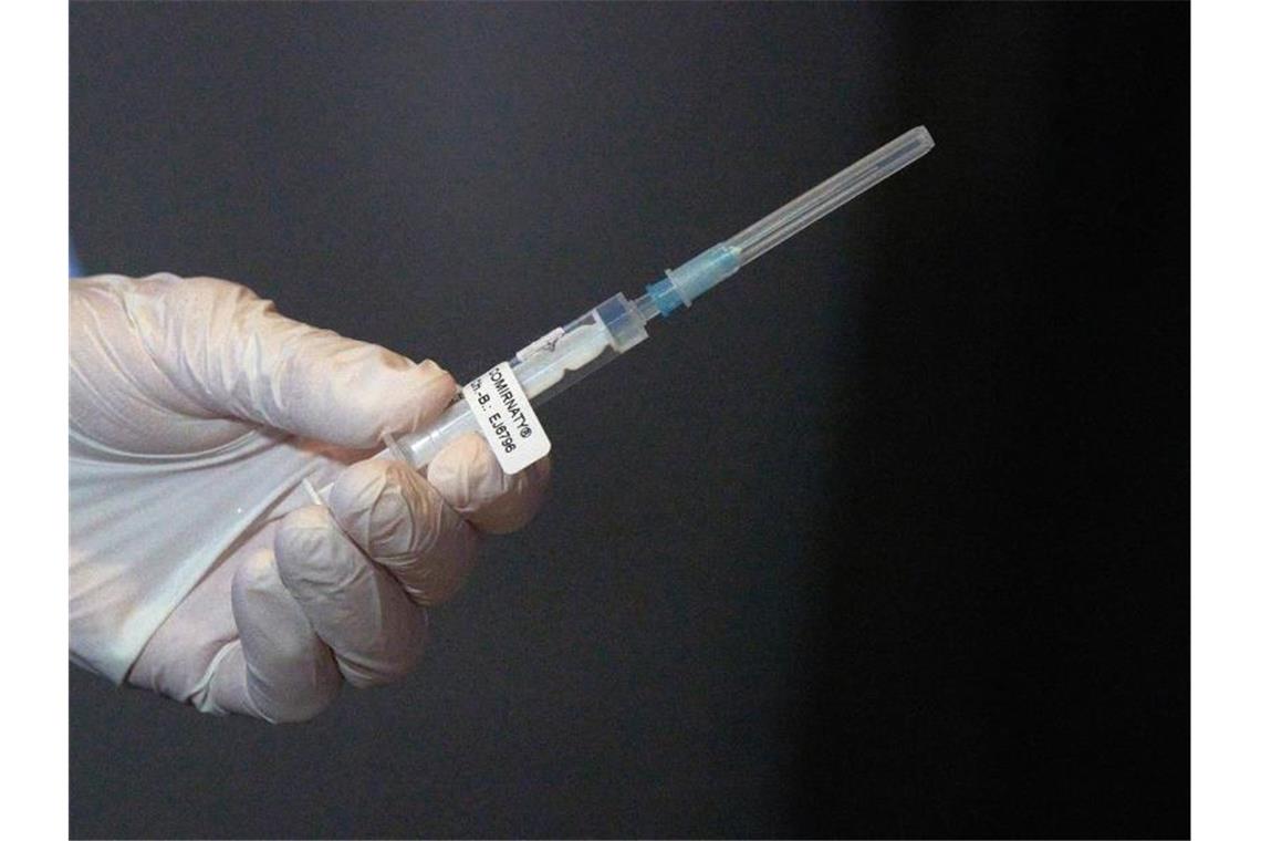 Eine Mitarbeiterin des Impfteams überprüft eine Spritze mit dem Impfstoff gegen Covid-19. Foto: Thomas Frey/dpa Pool/dpa/Archivbild