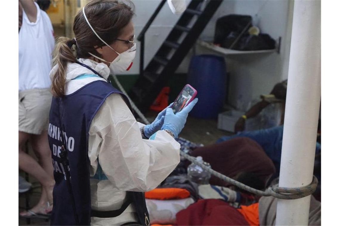 Eine Mitarbeiterin des italienischen Gesundheitsministeriums fotografiert die Zustände an Deck des Rettungsschiffes „Open Arms“. Foto: Francisco Gentico/AP