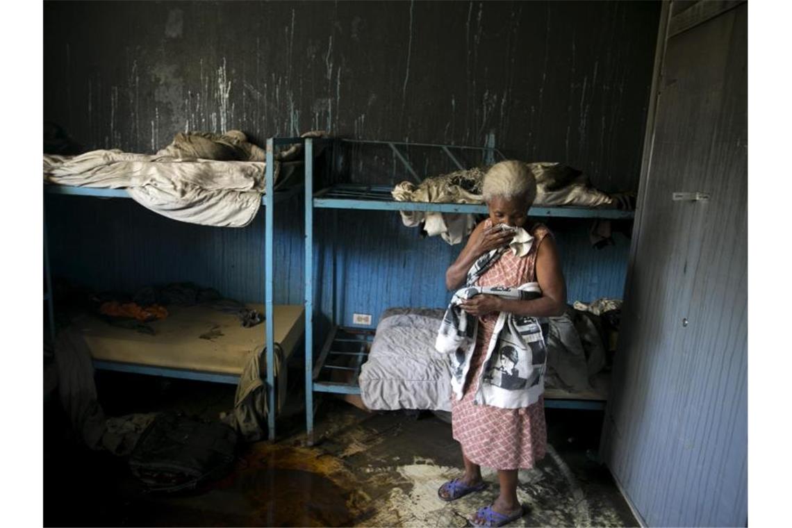 Eine Mitarbeiterin des von Flammen verwüsteten Waisenhauses steht in einem Schlafzimmer. Foto: Dieu Nalio Chery/AP/dpa