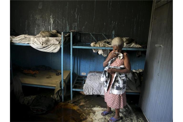 Eine Mitarbeiterin des von Flammen verwüsteten Waisenhauses steht in einem Schlafzimmer. Foto: Dieu Nalio Chery/AP/dpa