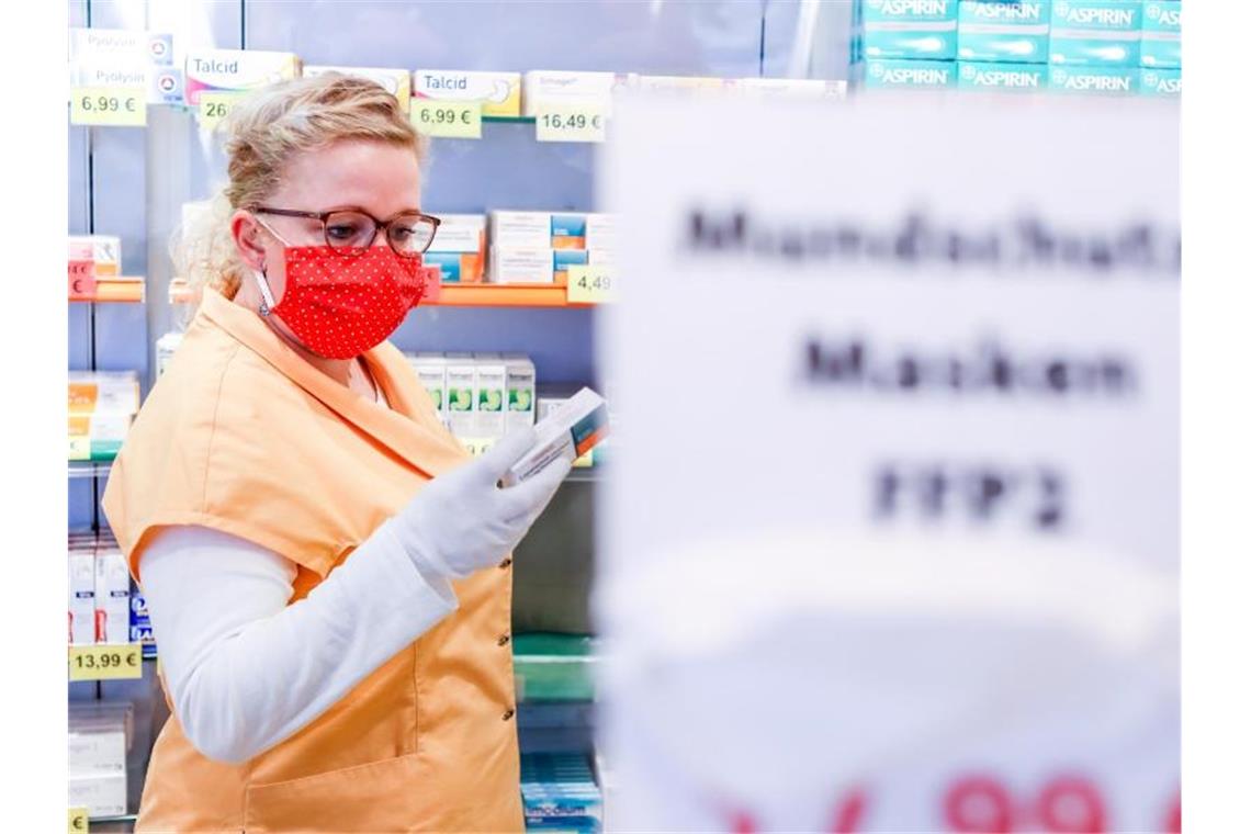 Eine Mitarbeiterin einer Leipziger Apotheke mit einem selbst genähten Mundschutz. Foto: Jan Woitas/dpa-Zentralbild/dpa
