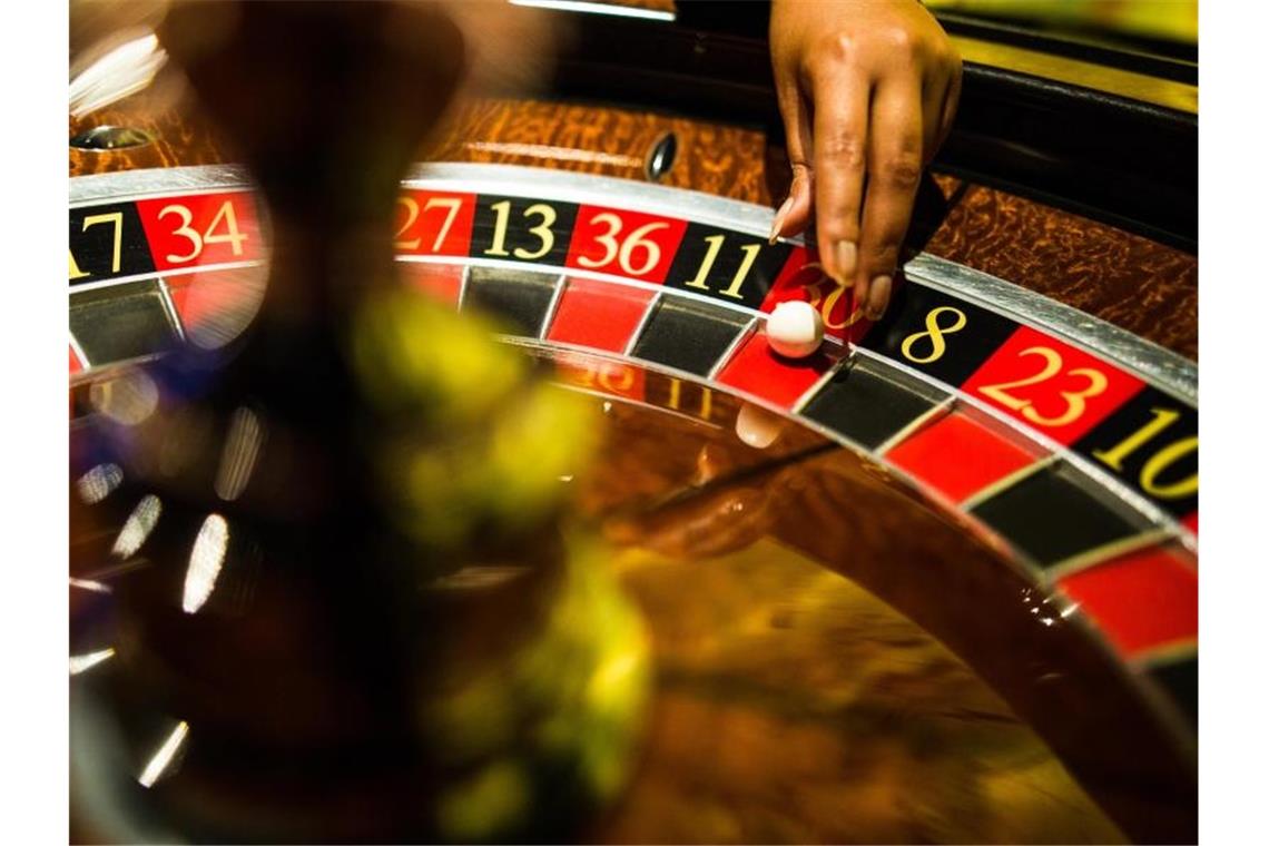 Spielbanken in Deutschland legen deutlich zu Eine Mitarbeiterin einer Spielbank greift beim Spiel Roulette nach einer Kugel, die auf Rot liegt. Foto: Christoph Schmidt/dpa/Archivbild